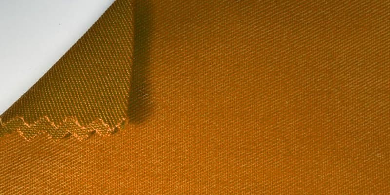 ผ้า Comb Twill สำหรับผลิตเสื้อช็อป ถ่ายมาโครเห็นลายทอทแยงและขอบผ้าที่ตัดด้วยกรรไกรฟันปลา